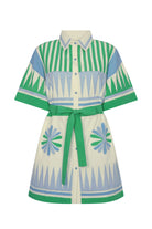 Person wearing a green and white striped outfit with a matching hat on a beige background