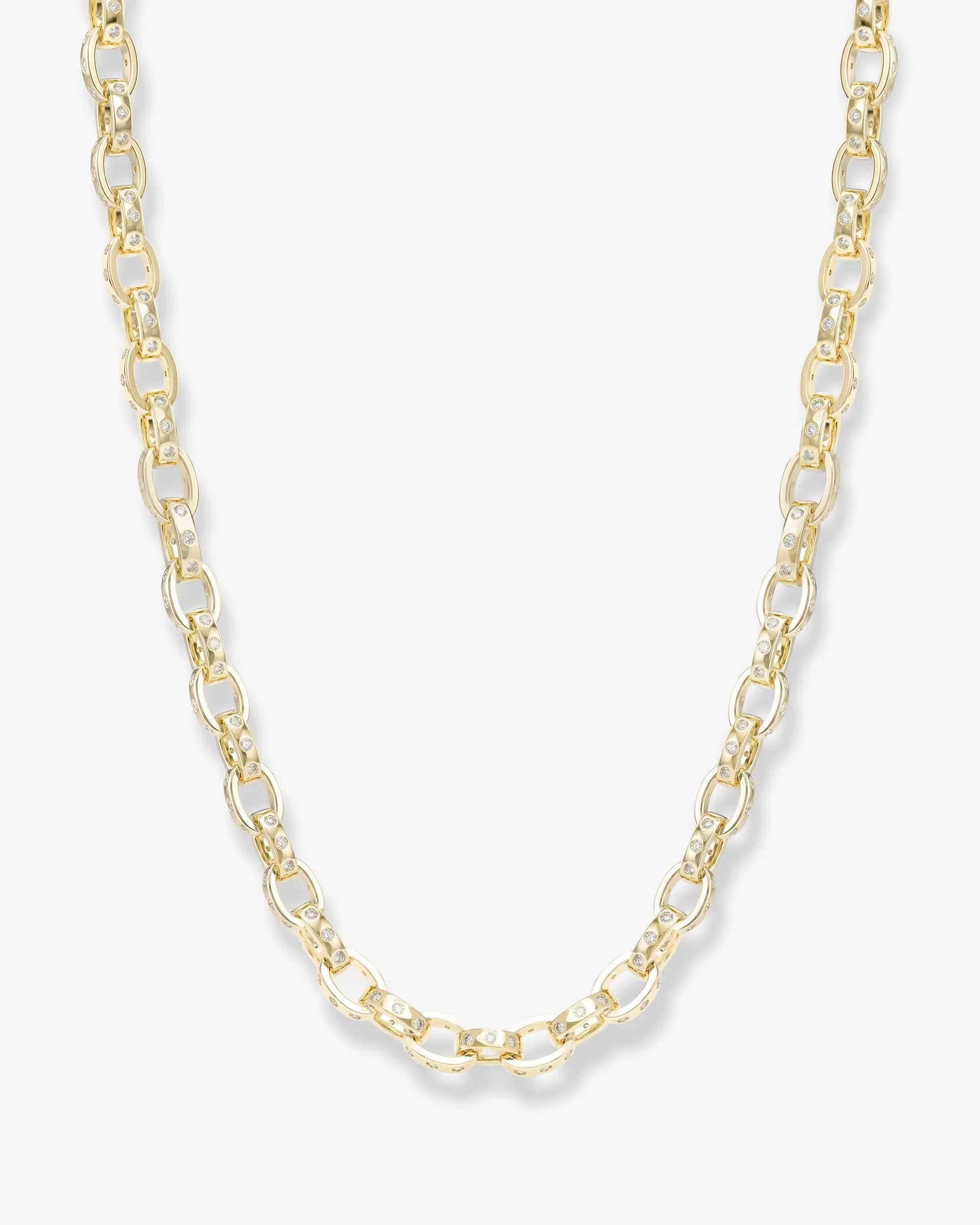A gold chain necklace with elongated oval links, displayed against a clean, light off-white background.