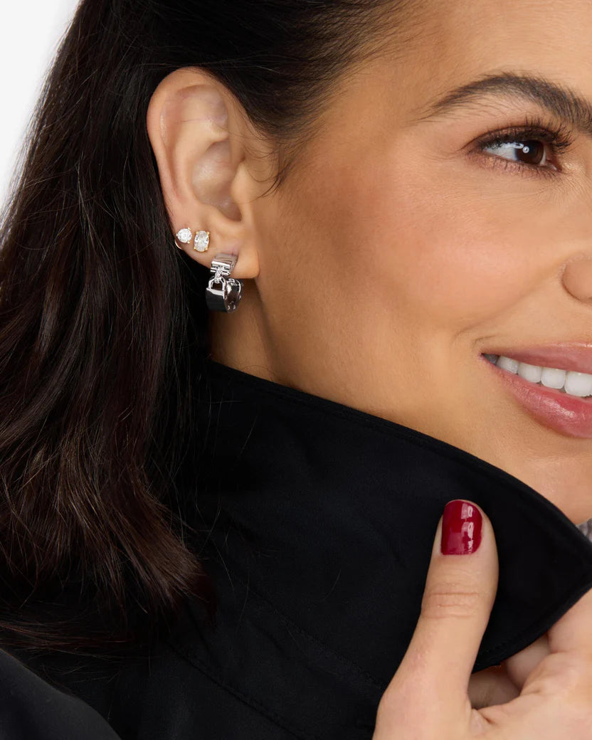 Close-up of a woman wearing a silver earring with a clear gemstone.