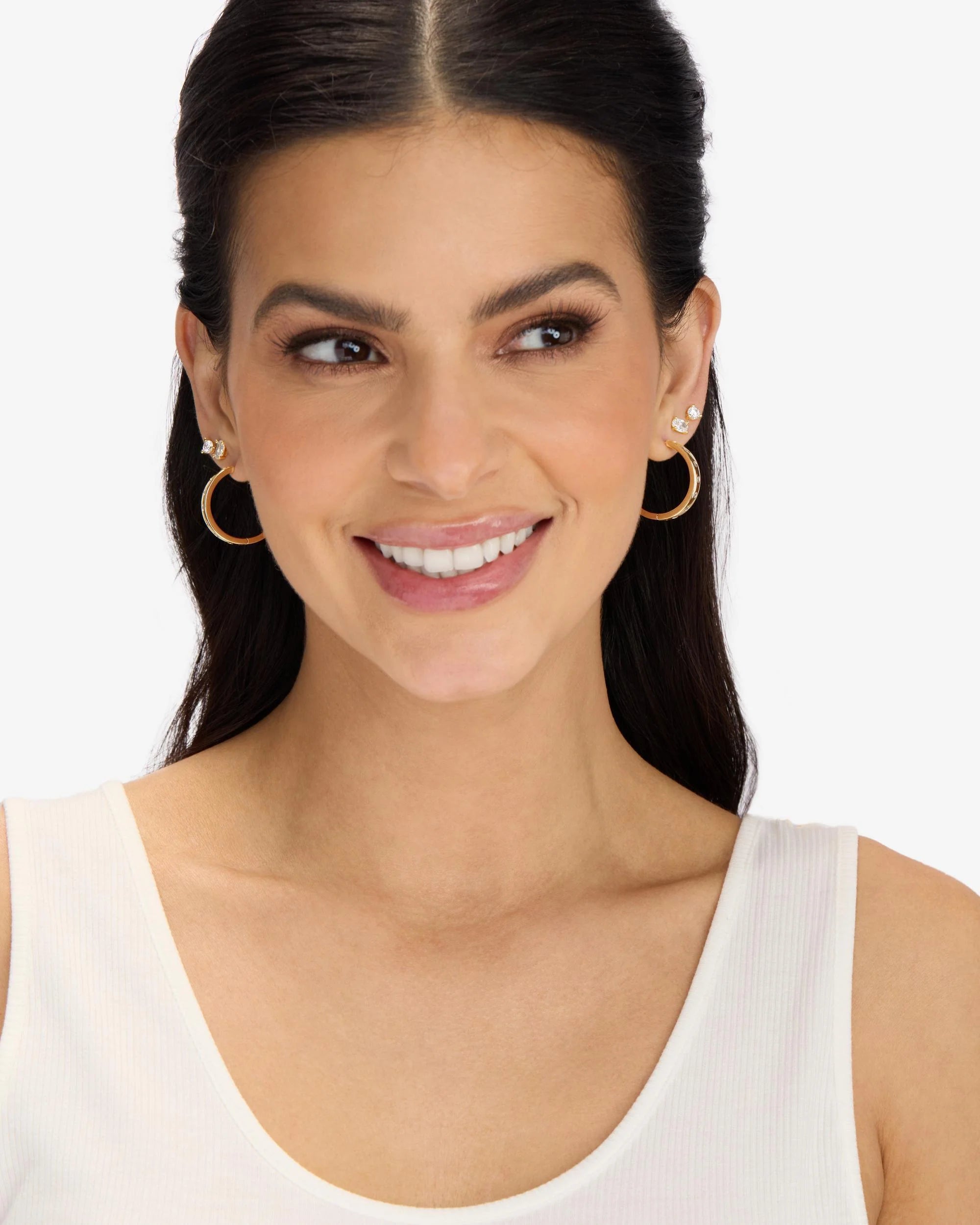 Woman wearing gold hoop earrings on a white background