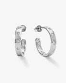 A pair of silver hoop earrings with small clear round-cut stones set along the front, shown on a clean light gray background.