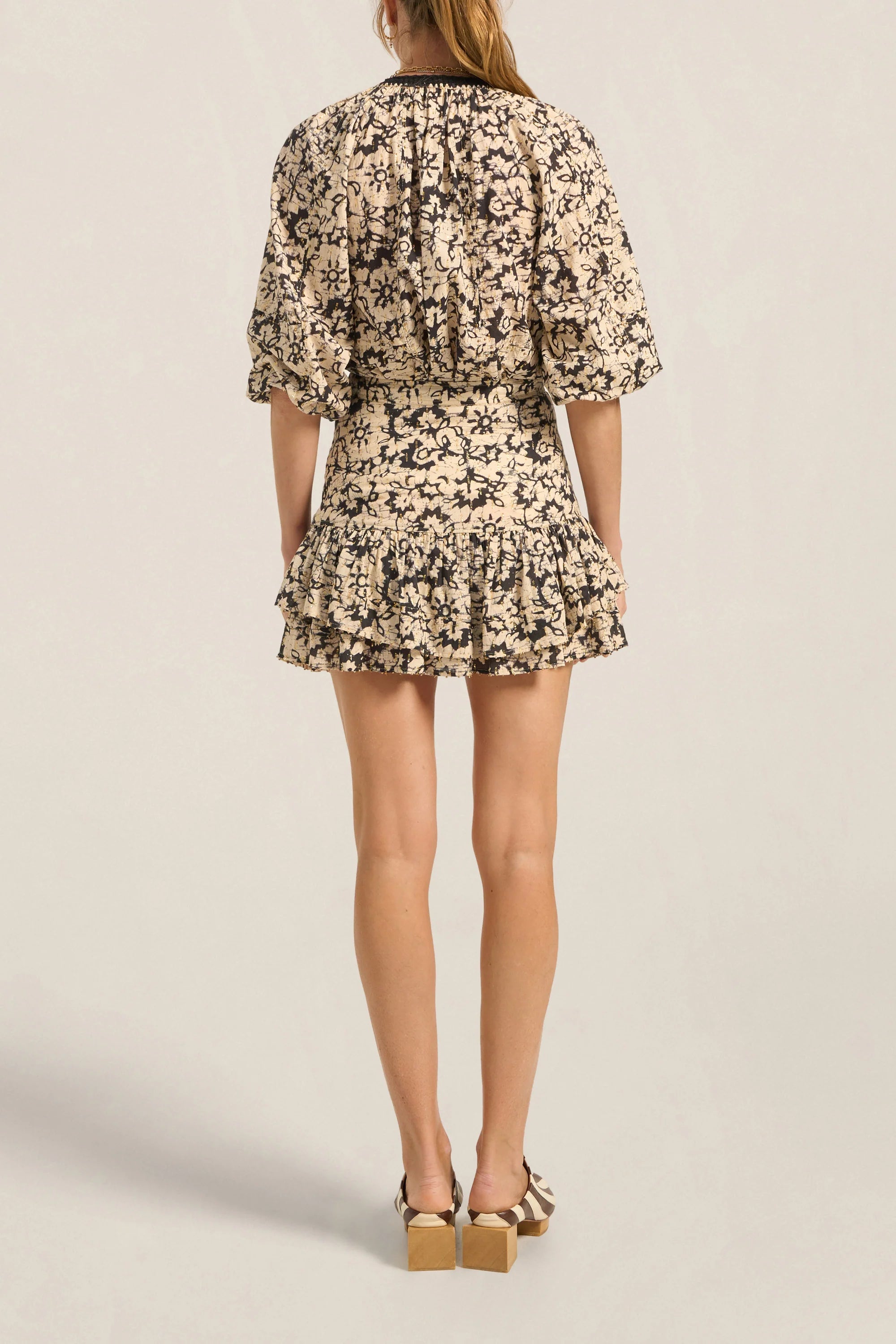 Woman wearing a floral dress on a plain background
