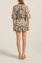 Woman wearing a floral dress on a plain background