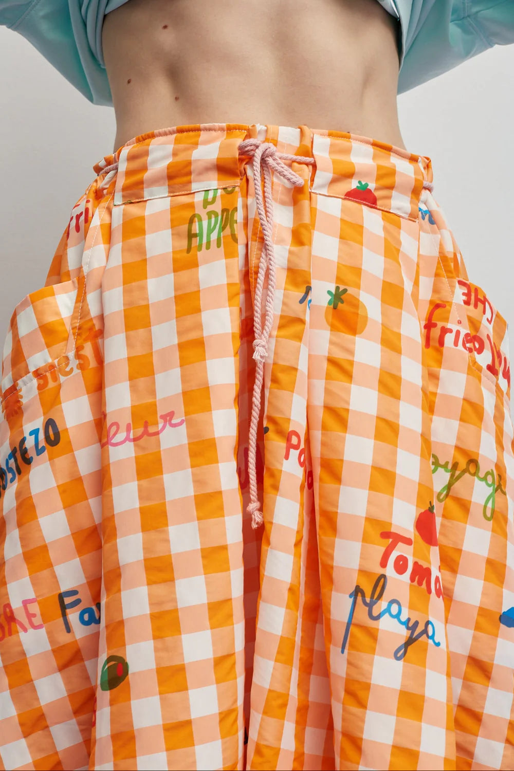 Orange checkered shorts with colorful text and graphics on a plain background