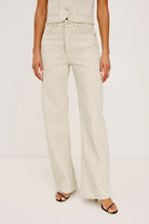 Person wearing beige wide-leg pants on a white background