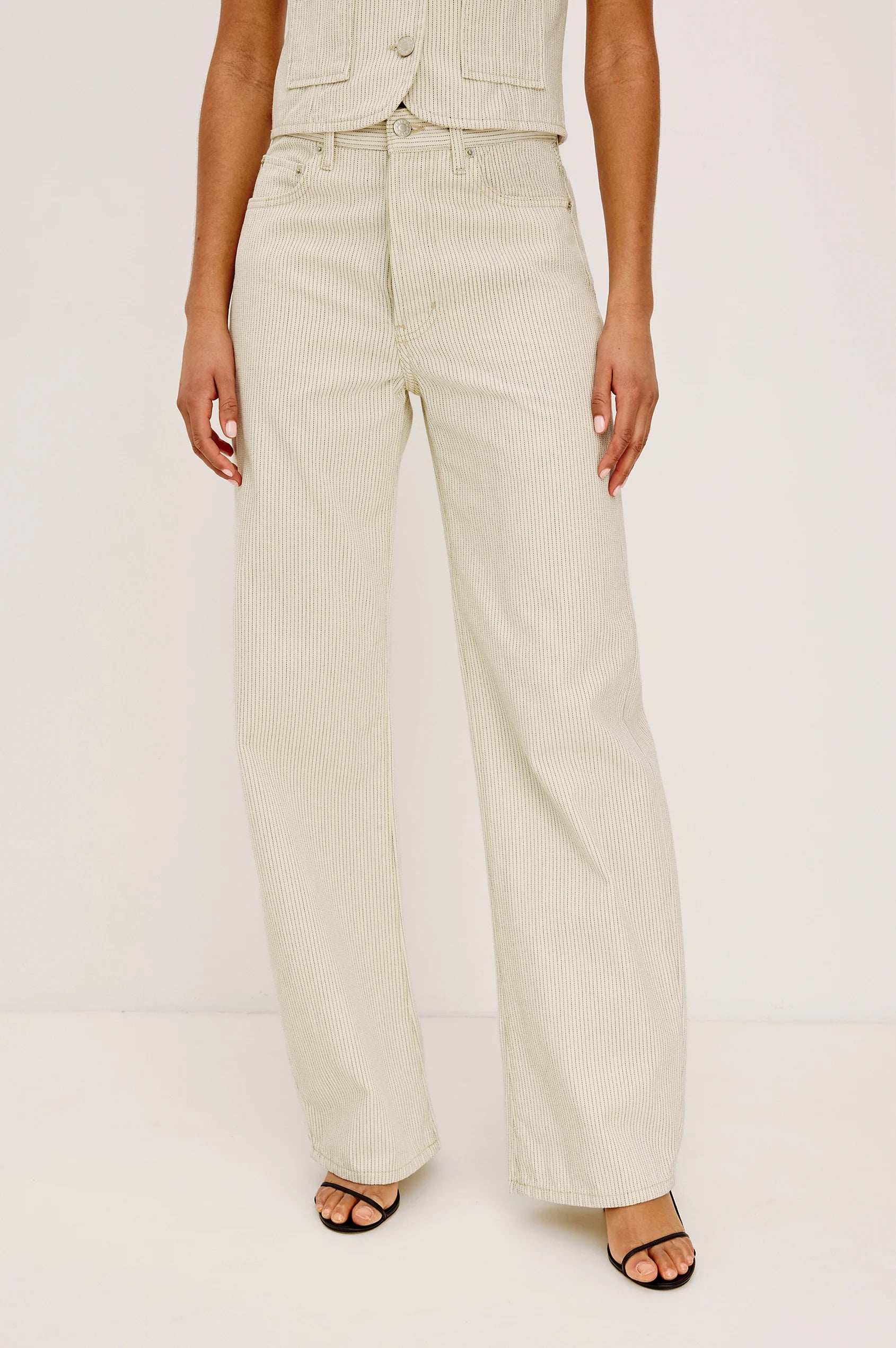 Person wearing beige pants on a white background