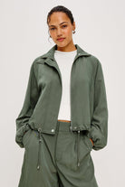 Woman wearing a green raincoat on a white background