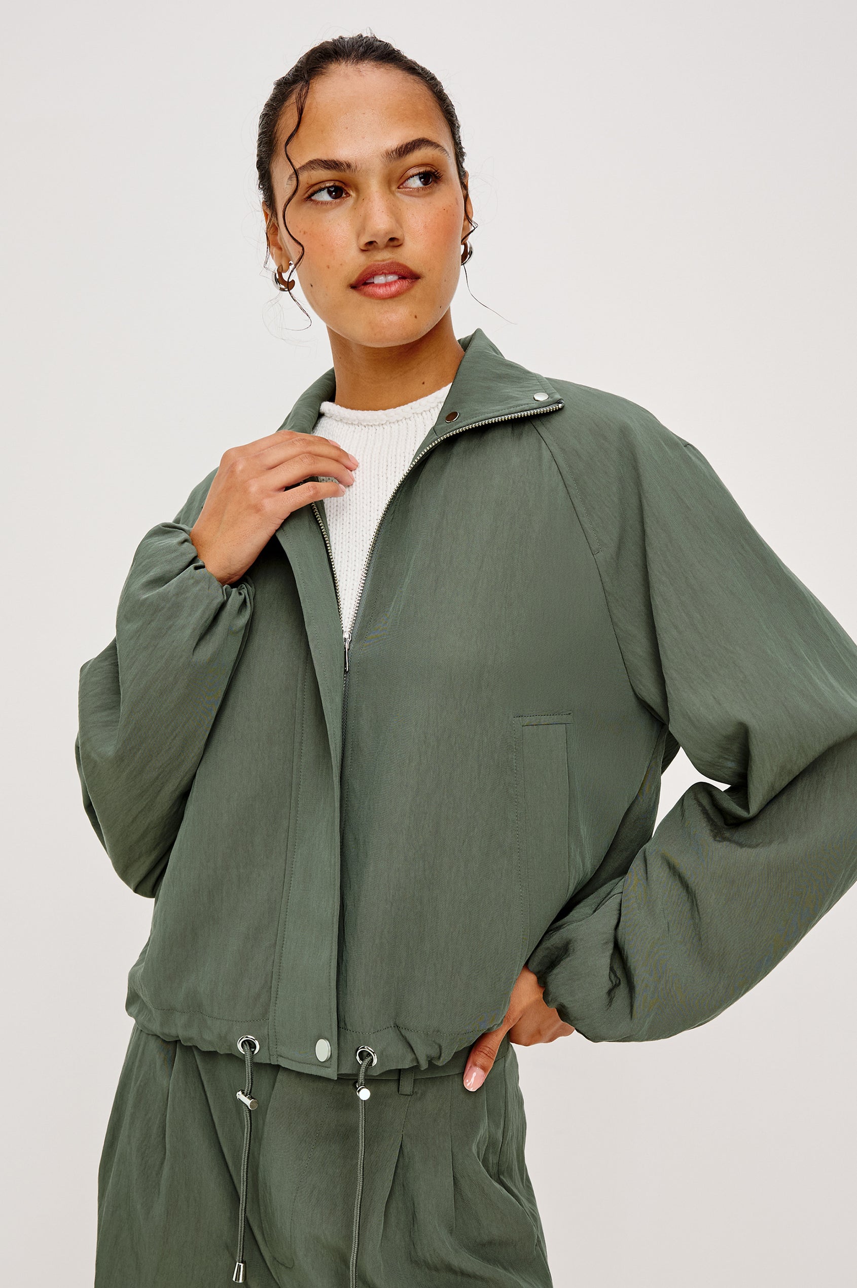 Woman wearing a green jacket and pants on a white background