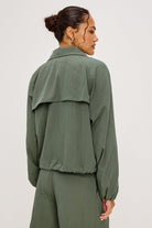 Woman wearing a green jacket and pants on a white background