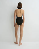 Person wearing a black swimsuit on a plain background