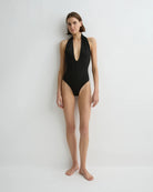 Woman wearing a black one-piece swimsuit on a white background