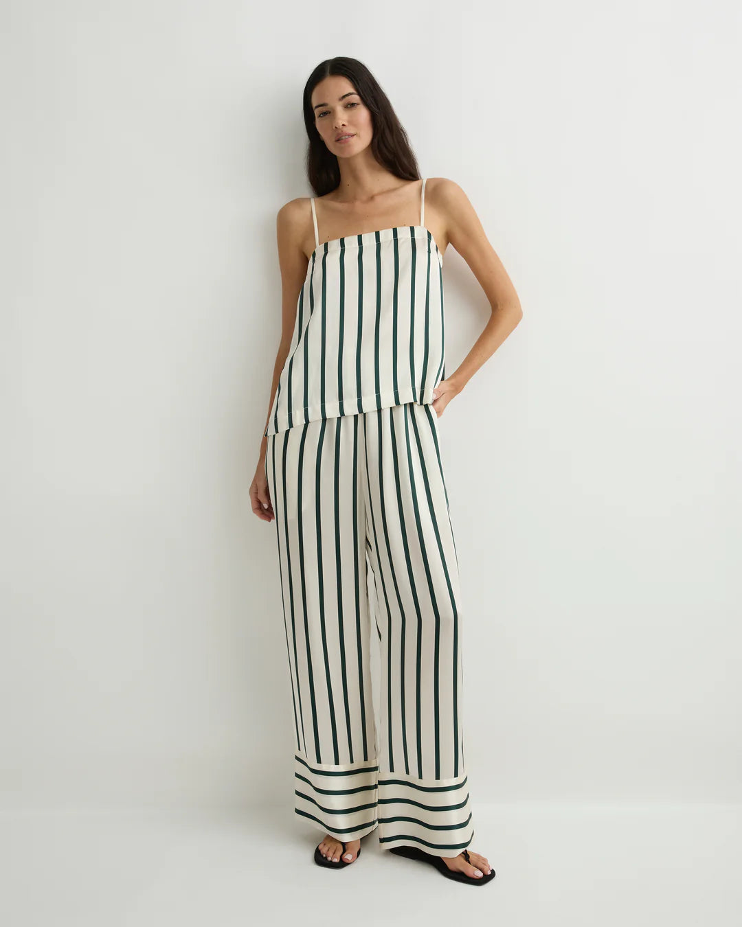 Woman wearing a black and white striped jumpsuit on a plain background