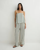 Woman wearing a black and white striped jumpsuit on a white background