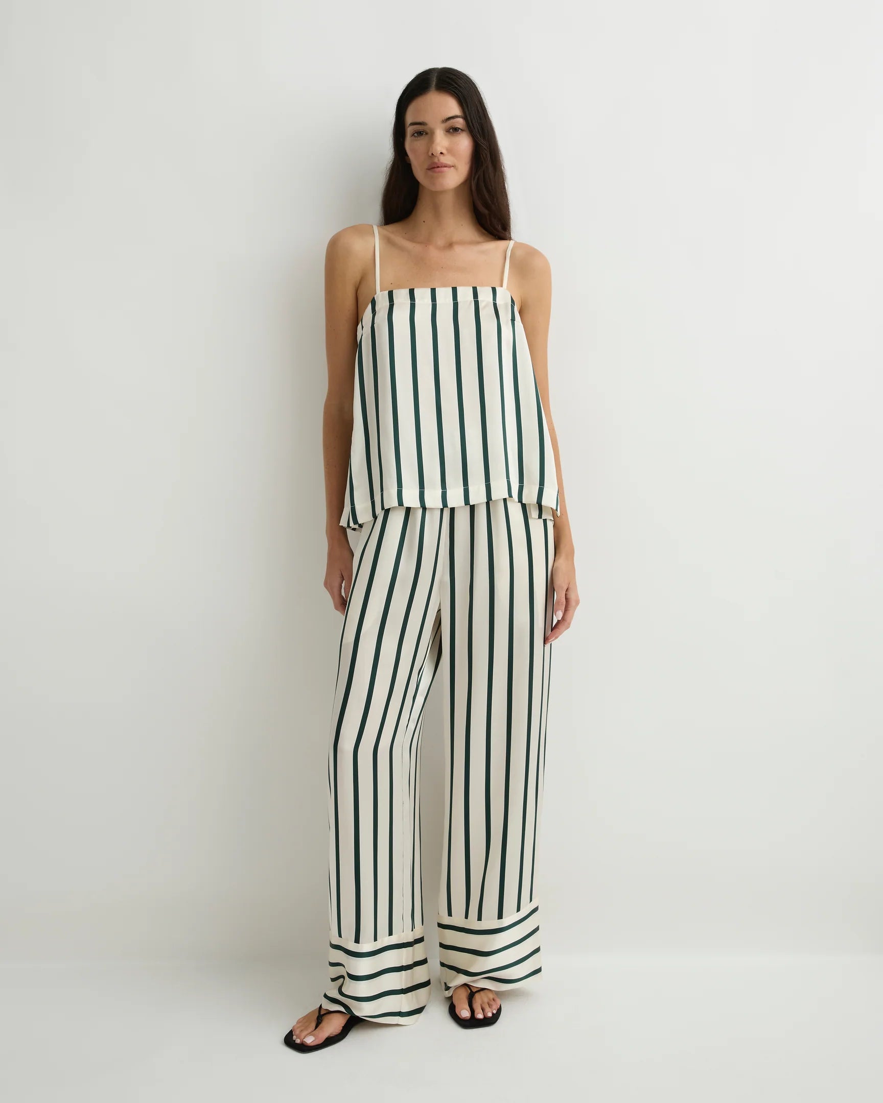 Woman wearing a black and white striped jumpsuit on a white background