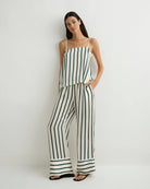 Woman wearing a black and white striped jumpsuit on a white background