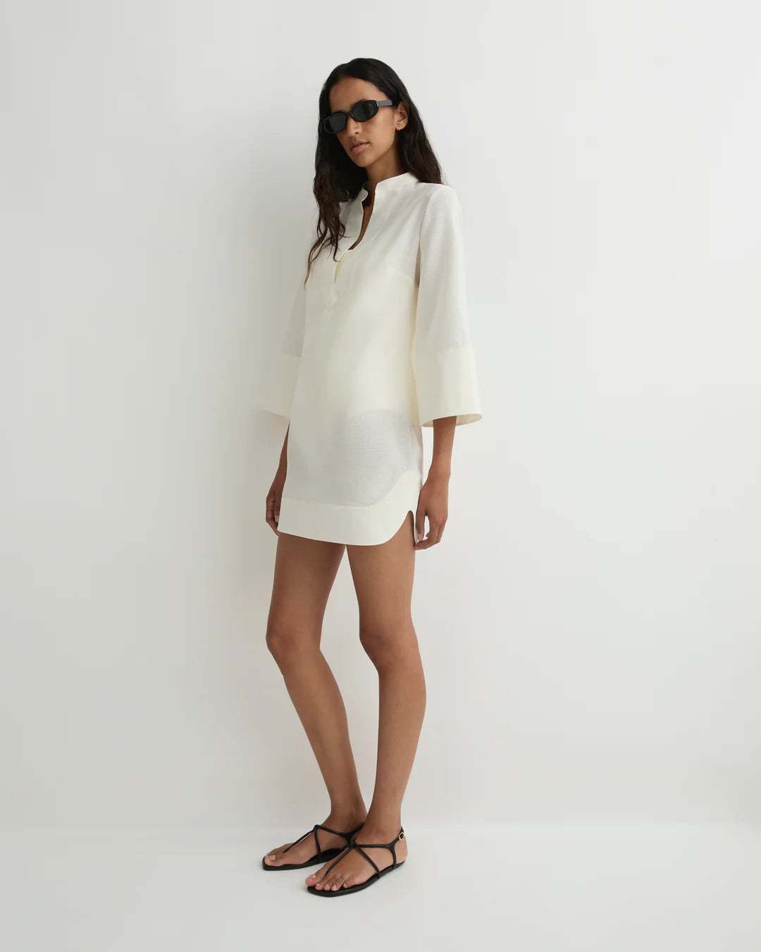 Woman wearing a white dress against a plain background