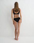 Person wearing a black bikini on a white background