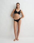 Woman wearing a black bikini on a white background
