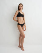 Woman wearing a black bikini on a white background