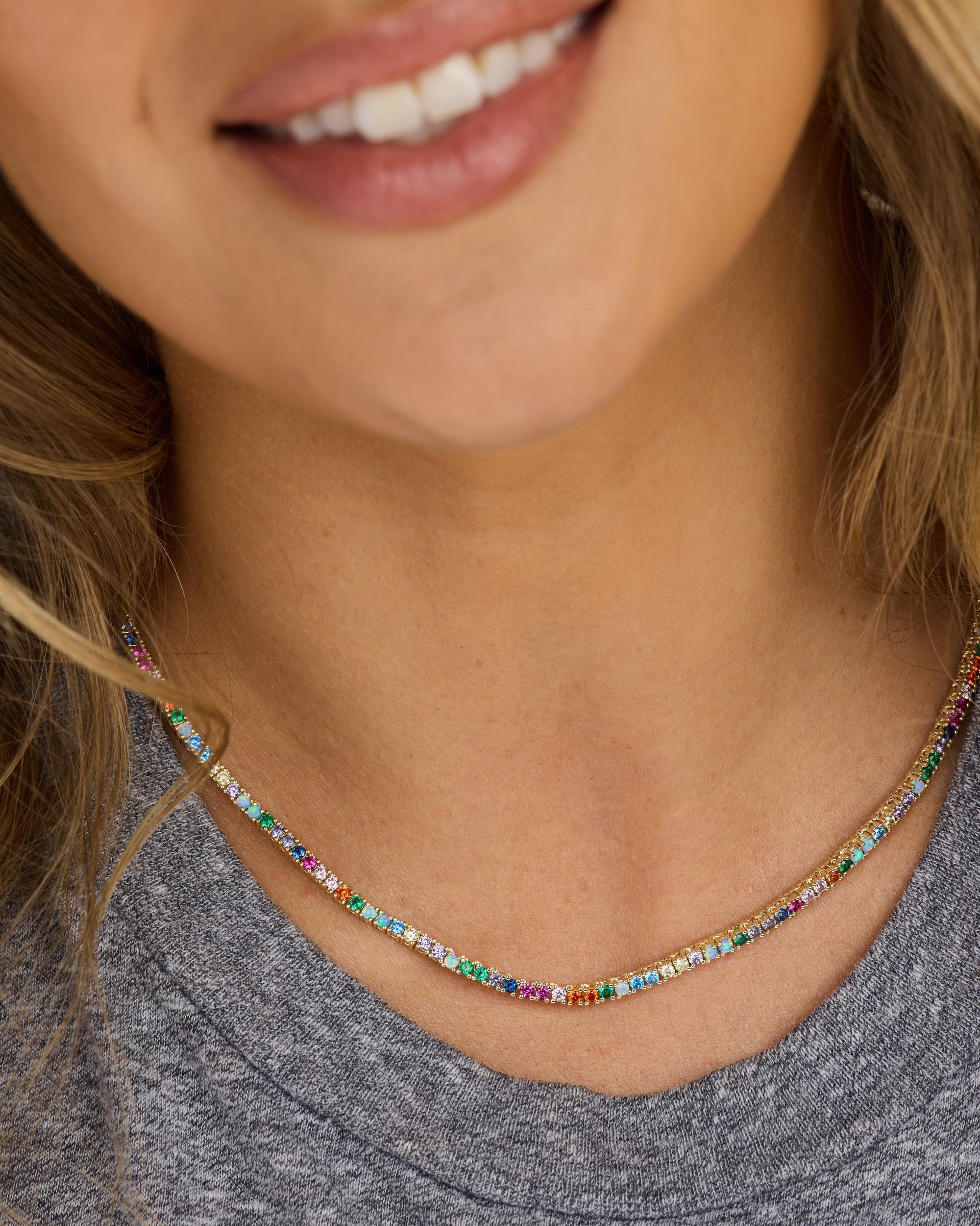 Close-up of a person wearing a colorful beaded necklace with a neutral background