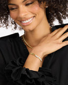 Woman wearing gold jewelry with a blurred background