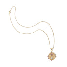 Gold necklace with a circular pendant on a white background