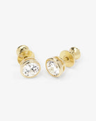 Gold stud earrings with clear gemstones on a white background