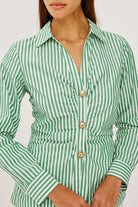 Green and white striped shirt with gold buttons on a plain background