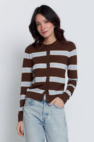 A woman wearing a brown and light gray striped button-up cardigan with a polo collar, paired with light-wash jeans, against a plain light gray background.