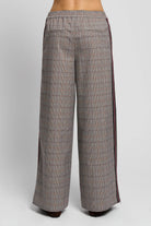 Wide-leg plaid trousers shown from the back, featuring a gray and brown check pattern with dark red side stripes and an elastic waistband.