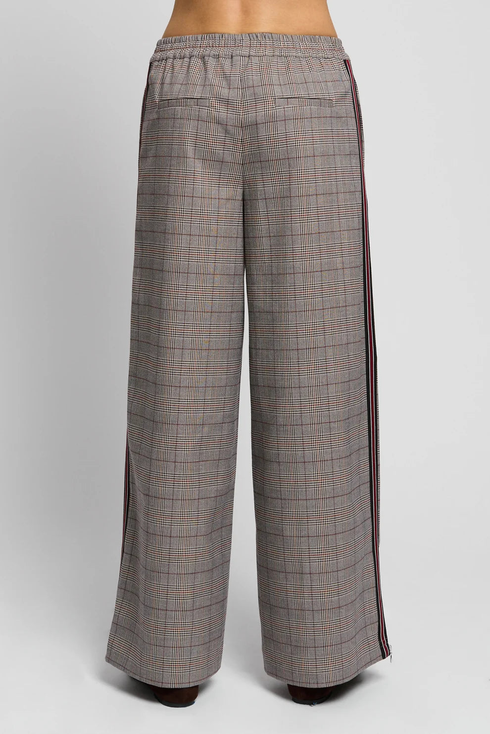 Wide-leg plaid trousers shown from the back, featuring a gray and brown check pattern with dark red side stripes and an elastic waistband.