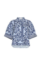 Blue and white patterned blouse on a white background