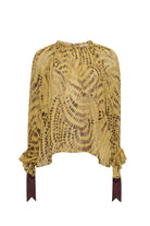 A yellow and brown patterned blouse with long sleeves, ruffled cuffs, and dark brown ribbon ties at the hem, shown against a plain white background.