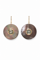A pair of drop earrings featuring large, round iridescent mother-of-pearl discs with a small faceted green gemstone in a gold bezel setting, suspended from gold hooks against a plain white background.