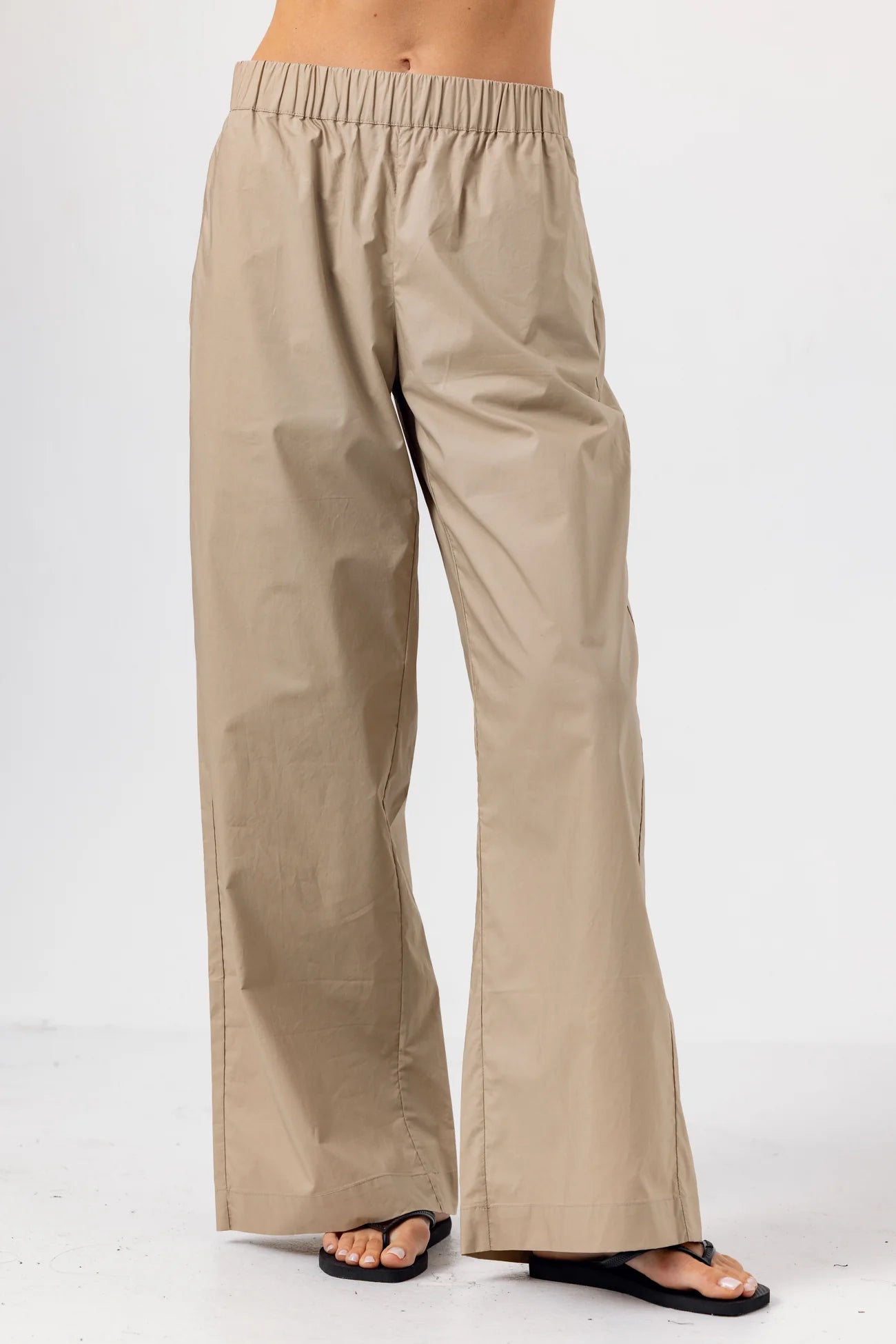 Beige wide-leg pants worn by a person on a white background