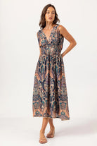 Woman wearing a patterned sleeveless dress on a white background