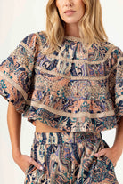 Woman wearing a patterned outfit with a white background