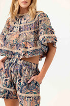 Woman wearing a patterned outfit with a white background