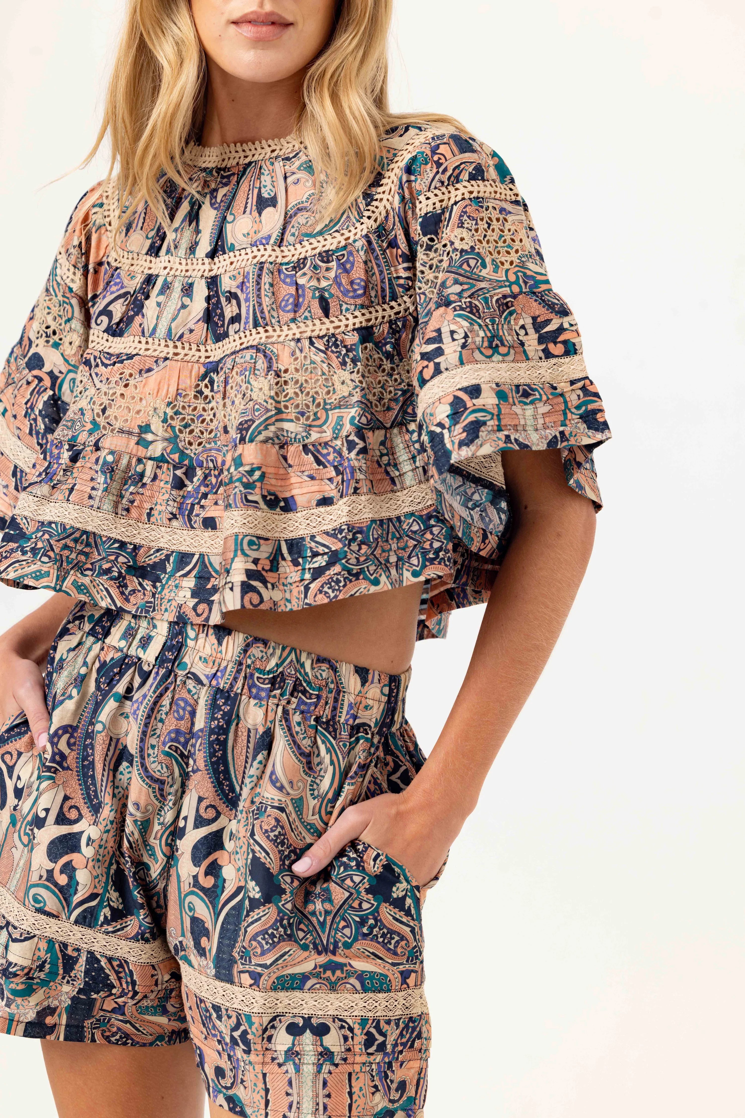 Woman wearing a patterned outfit with a white background