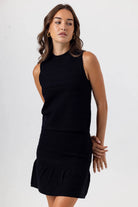 Woman wearing a black dress against a white background