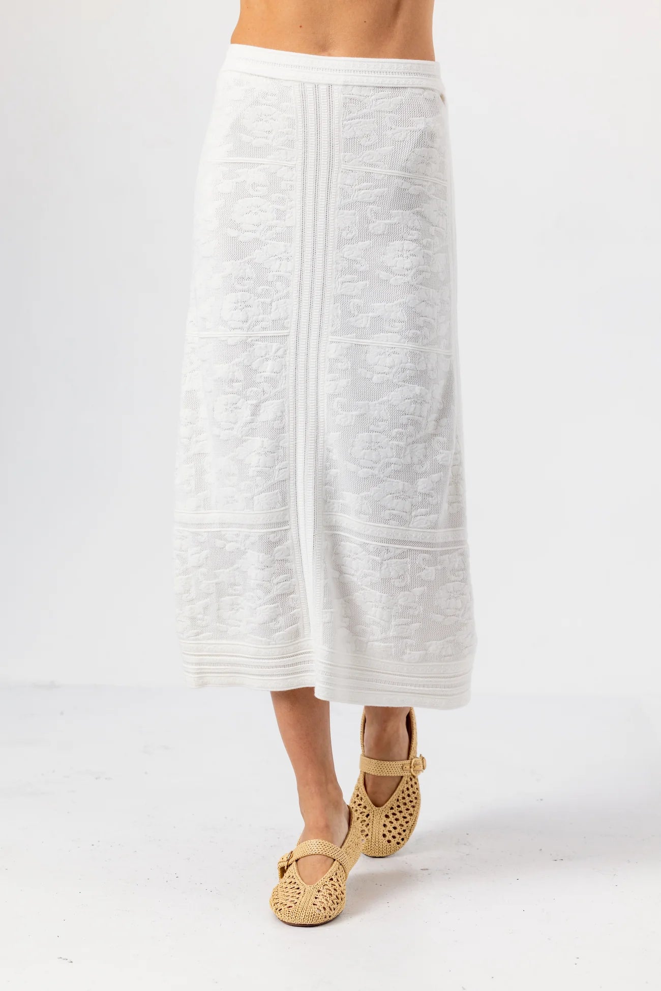 White textured skirt worn by a person on a white background