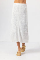 White textured skirt worn by a person on a white background
