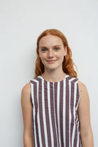 Woman wearing a striped dress against a plain background