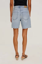 Light blue denim shorts worn by a person on a plain background
