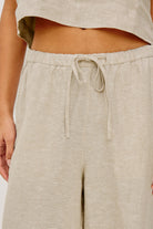 Beige linen pants with a drawstring waist on a white background