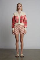 Person wearing a red and white striped outfit against a plain background