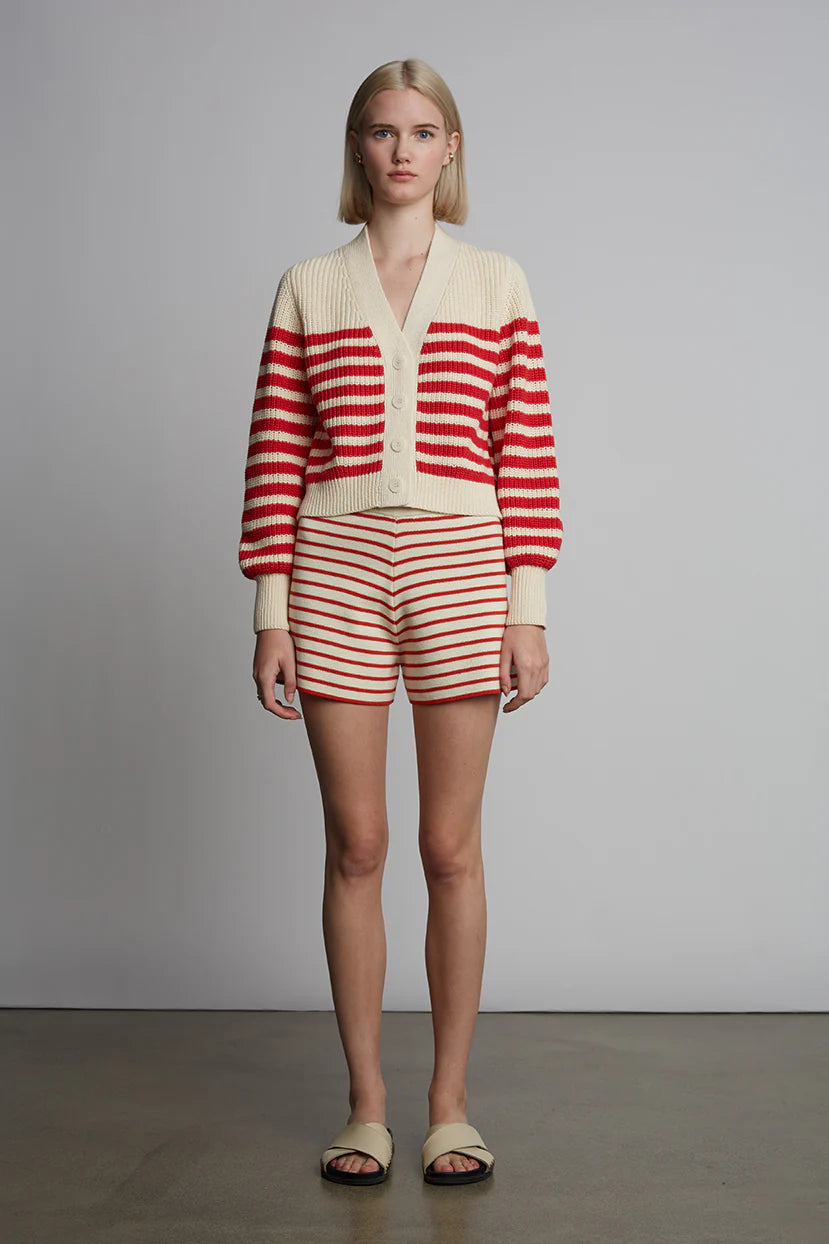 Person wearing a red and white striped outfit against a plain background