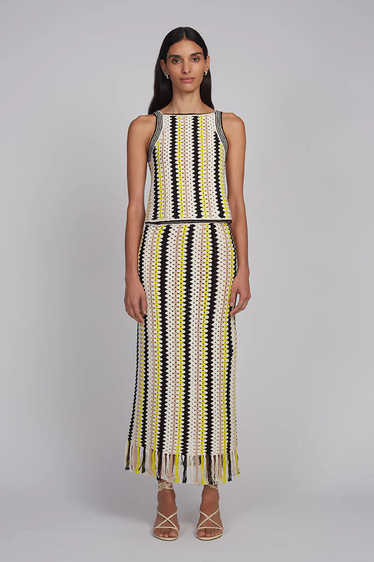 Woman wearing a sleeveless dress with a geometric pattern on a gray background