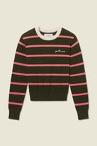 Black and pink striped sweater with a brand logo on a beige background