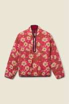 A pink quilted jacket with a floral print, featuring a half-zip front with a dark red lining and a black zipper pull, displayed flat against a light beige background.
